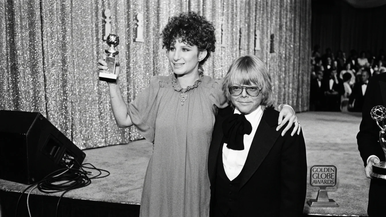 American singer and actress Barbra Streisand and American composer and actor Paul Williams hold their Golden Globe awards for Best Original Song - Motion Picture for their song 'Evergreen (Love Theme from A Star Is Born)' at the 34th Annual Golden Globe Awards, held at the Beverly Hilton Hotel, Beverly Hills, California, January 29, 1977.
